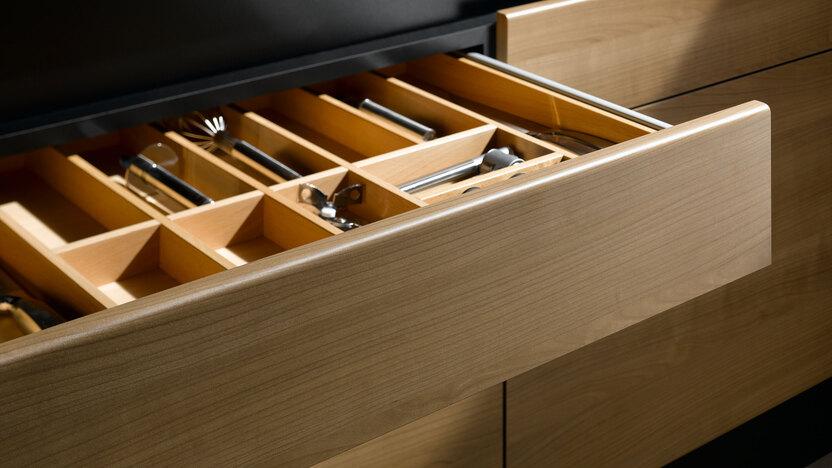 Detailaufnahme einer Besteckschublade aus Massivholz Detailaufnahme einer Besteckschublade aus hellem Massivholz